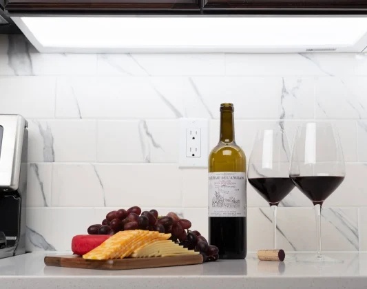 Kitchen counter with wine and cheese; Marble backsplash with wine and grapes